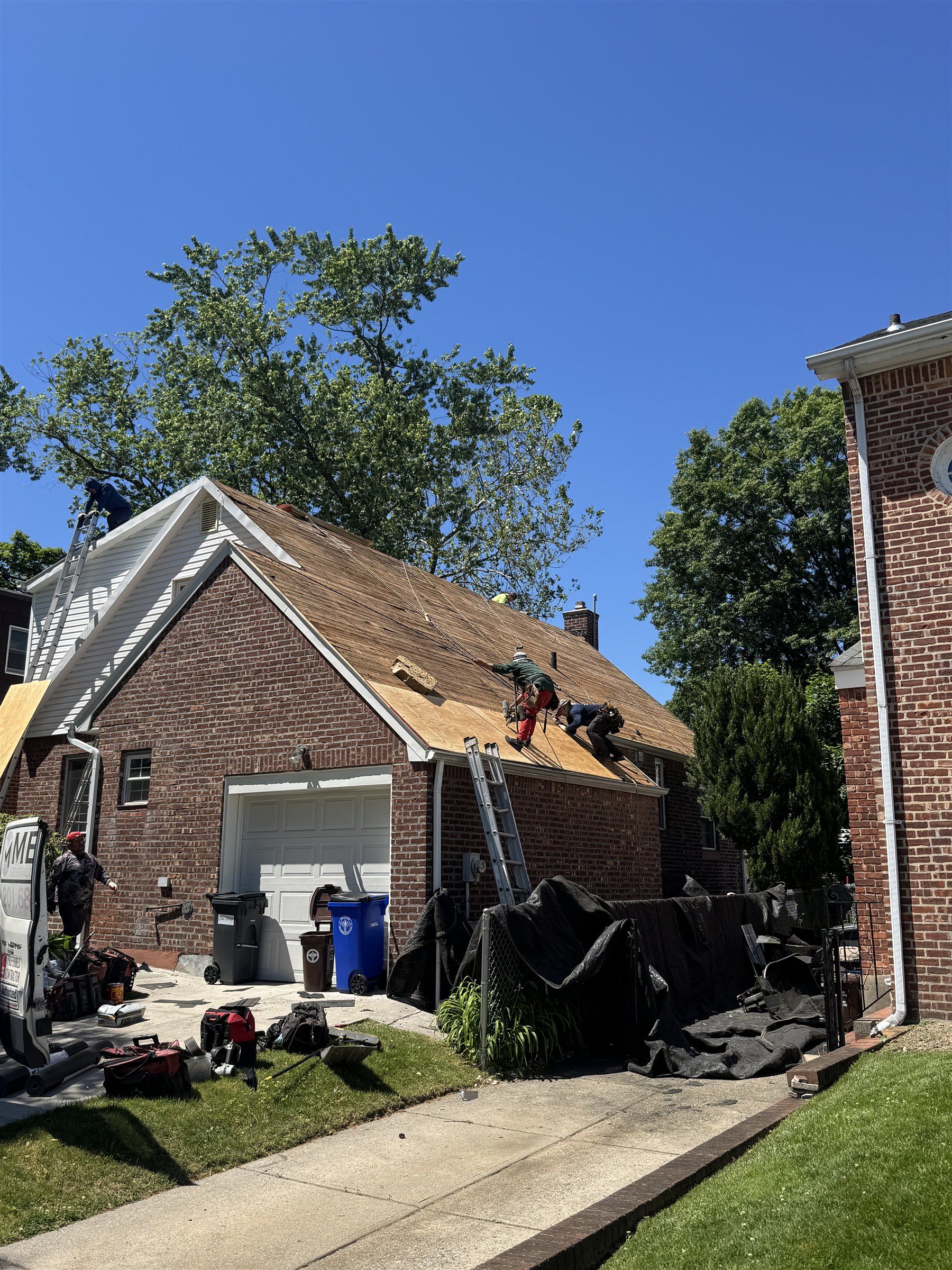 Roofers working on a brick home in New Jersey