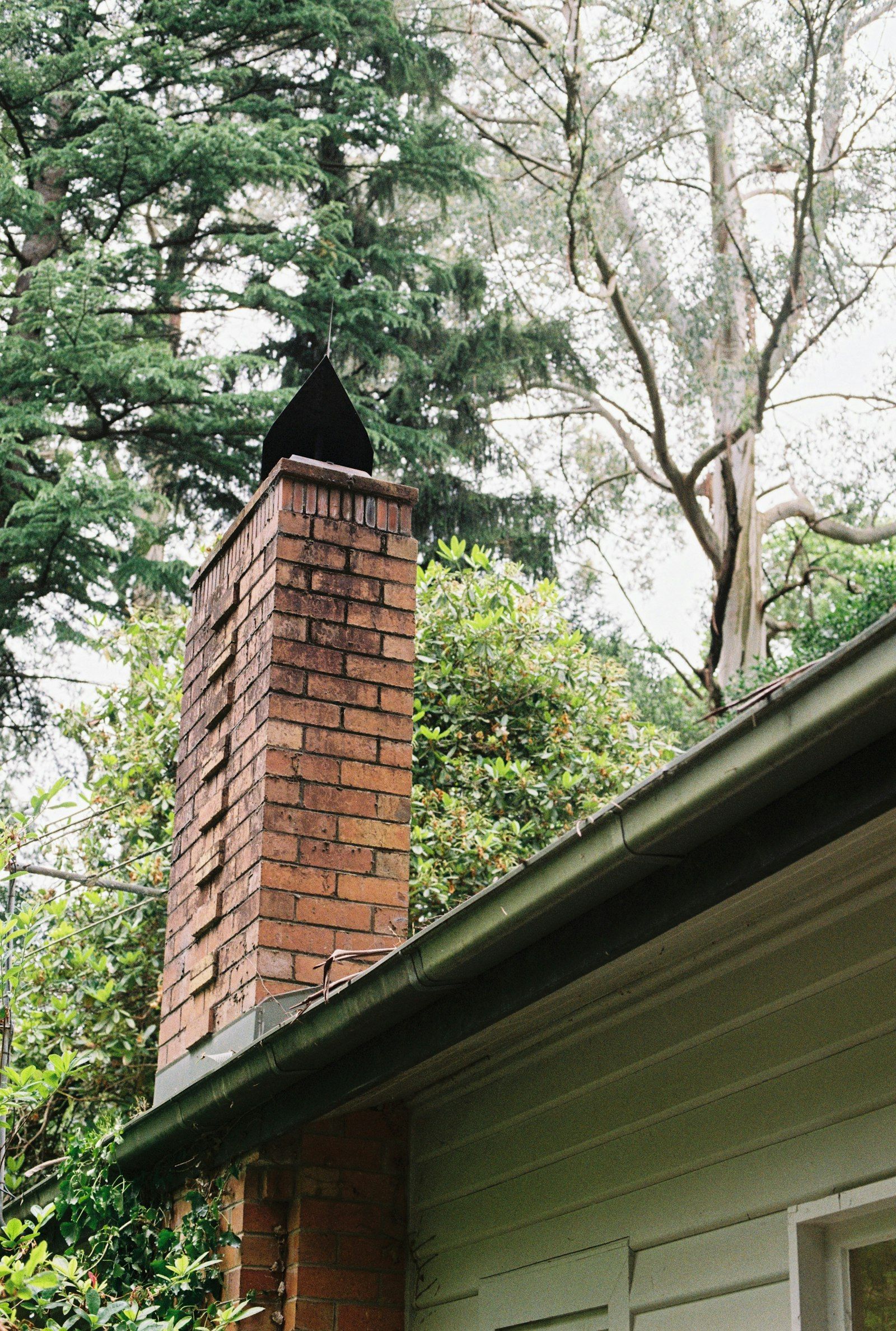 Brick chimney beside a sided house