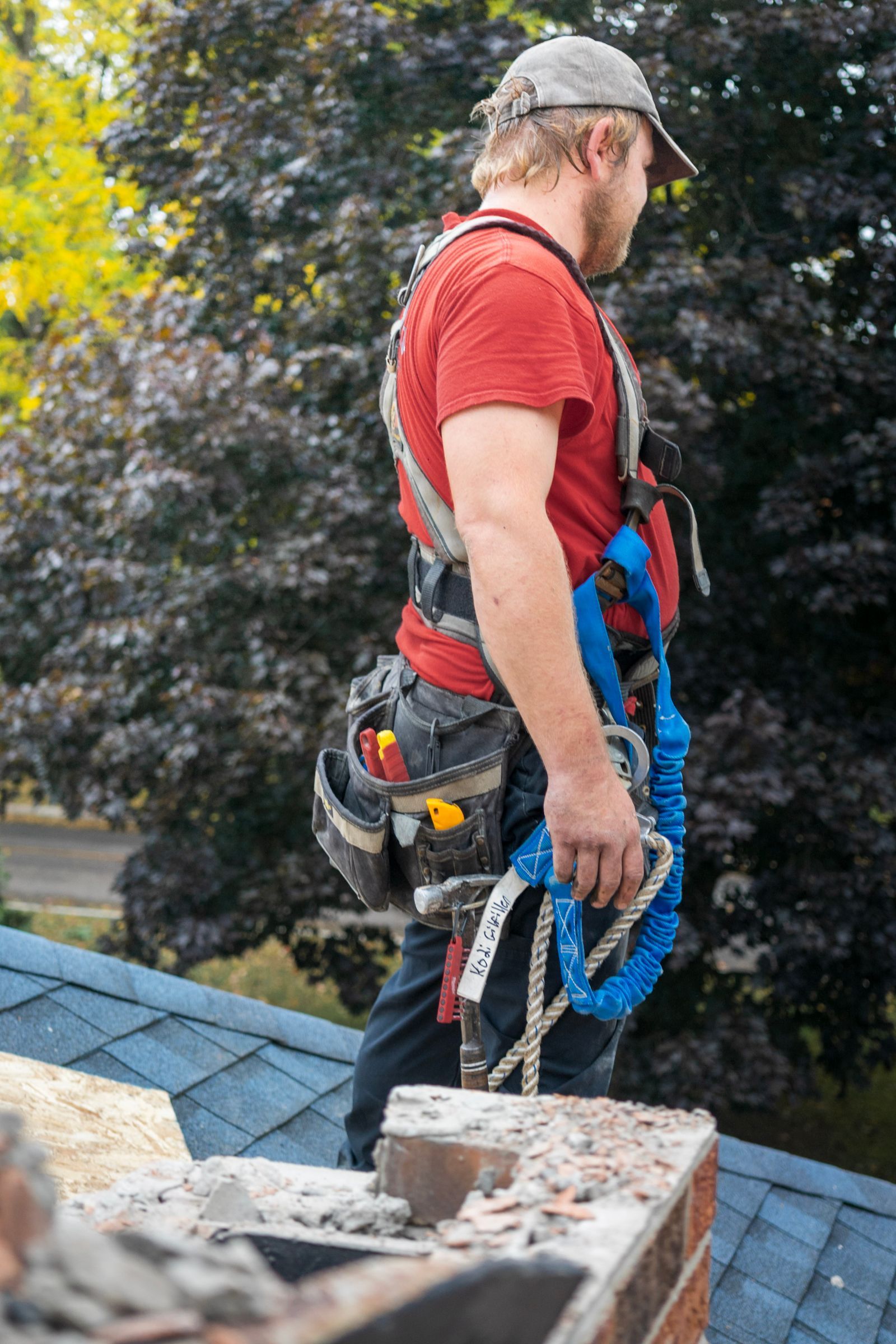 Roofer in harness by the chimney