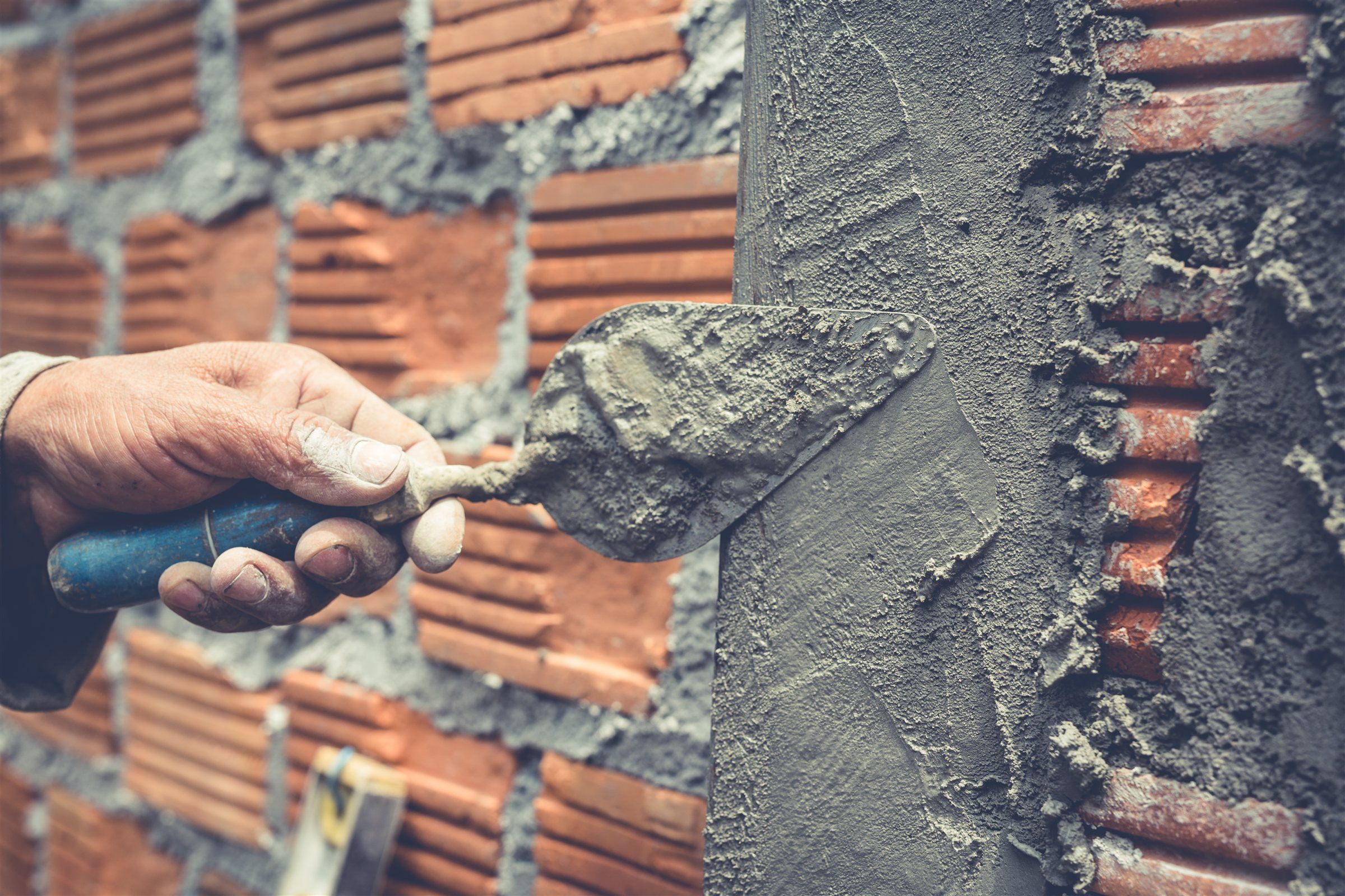 Mason applying mortar to brickwork with a trowel