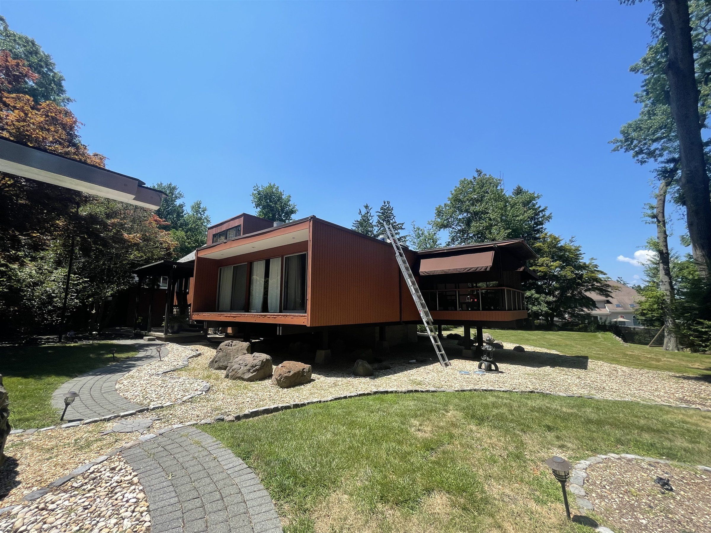 Wood-clad mid-century modern home in a landscaped yard
